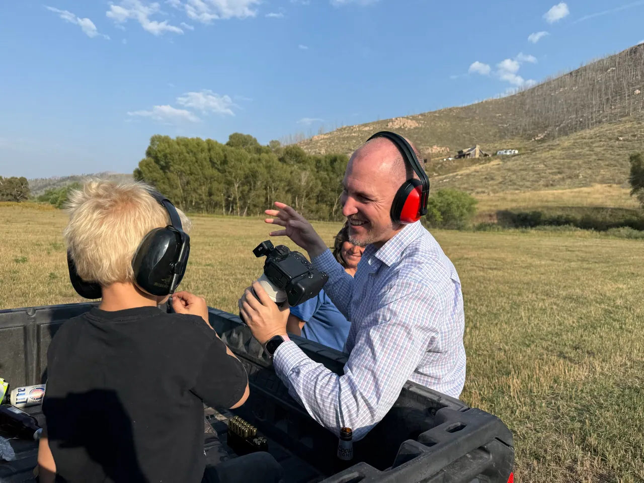 Camera operator wearing headphones beside a collaborator in an off-road vehicle